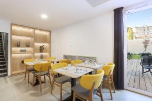 a dining room with tables and yellow chairs at Appart Hotel Odalys City Toulouse Centre Compans Caffarelli in Toulouse
