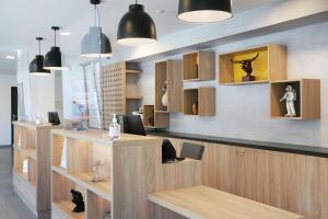 a lobby with a desk with two chairs and some lights at Appart Hotel Odalys City Toulouse Centre Compans Caffarelli in Toulouse