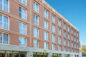 a large red brick building with windows at Appart Hotel Odalys City Toulouse Centre Compans Caffarelli in Toulouse