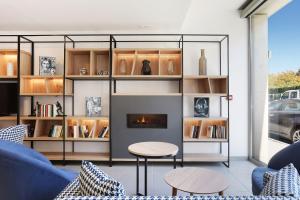 a living room with a fireplace and a blue couch at Appart Hotel Odalys City Toulouse Centre Compans Caffarelli in Toulouse