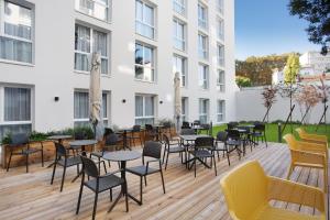 a patio with tables and chairs in front of a building at Appart Hotel Odalys City Toulouse Centre Compans Caffarelli in Toulouse