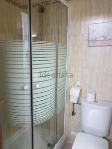 Un baño con ducha de cristal y un inodoro. en Italia 57, en Huelva