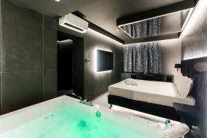 a bathroom with a bath tub and a bed at Motel Hotel Charlie in Settala