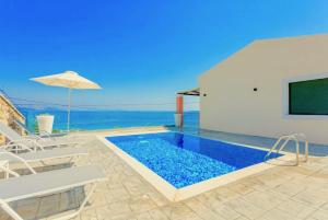 Ano Pyrgi的住宿－Luxury Villa Akti Barbati 3 with private pool，房屋内带椅子和遮阳伞的游泳池