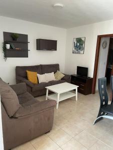 una sala de estar con un sofá y una mesa en Italia 57, en Huelva