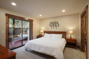a bedroom with a large bed and a balcony at 3 Tumalo with Wood Burning Fireplace in Sunriver