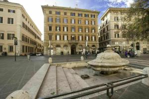 un banco en medio de una ciudad con edificios en Vittorio Emanuele, en Roma