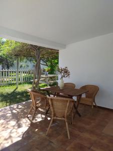 una mesa de madera y sillas en un patio en Las Casas de las Flores, en Los Caños de Meca