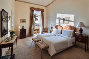 
a hotel room with two beds and a table at Sofitel Winter Palace Luxor in Luxor
