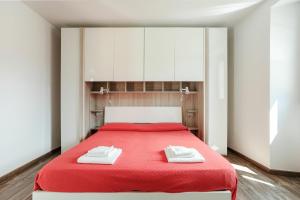 ein Schlafzimmer mit einem roten Bett mit zwei Handtüchern darauf in der Unterkunft Cremia Suits in Cremia
