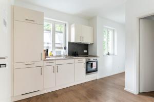 a white kitchen with white cabinets and a stove at Apartments Passau Angerstraße in Passau