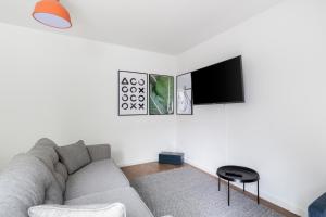 uma sala de estar com um sofá e uma televisão de ecrã plano em limehome Passau Angerstraße em Passau