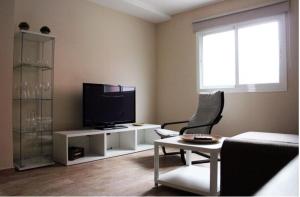 a living room with a tv and a couch at Apartamentos Albeniz in Algeciras +34 photos