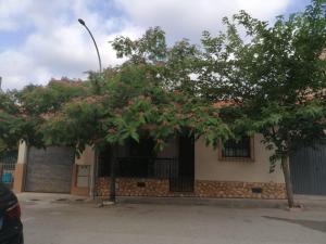 einen Baum mit rosa Blumen vor einem Gebäude in der Unterkunft Casa Rural El Cerrete 2 in Riópar