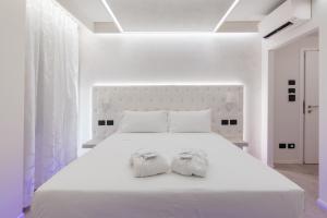 una camera bianca con un grande letto bianco con due asciugamani di Motel Hotel Charlie a Settala