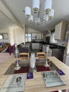 a kitchen and living room with a table with two plates on it at Romney Lodge in New Romney