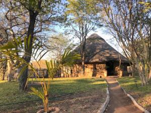 ein Gebäude mit einem Strohdach in einem Park in der Unterkunft Bungalow 3 on this world renowned Eco site 40 minutes from Vic Falls Fully catered stay - 1987 in Victoriafälle