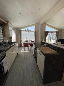 a kitchen with a table and a dining room at Romney Lodge in New Romney