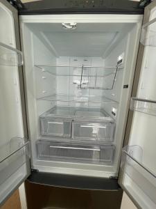 an empty refrigerator with its door open in a kitchen at Romney Lodge in New Romney