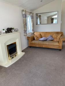 a living room with a couch and a fireplace at Romney Lodge in New Romney