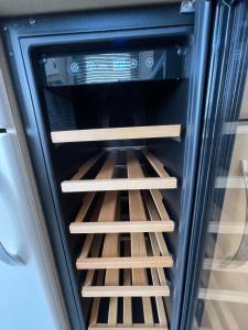 an open refrigerator with wooden shelves in it at Romney Lodge in New Romney +24 photos