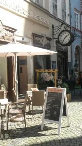 a restaurant with a table and chairs and a clock at Stadthaus Laucha in Laucha