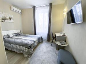 a bedroom with a bed and a desk and a television at Готель Elisavetgrad in Kropyvnytskyi