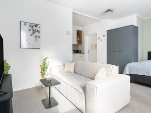 a living room with a white couch and a bed at limehome Linz Friedrichstraße in Linz
