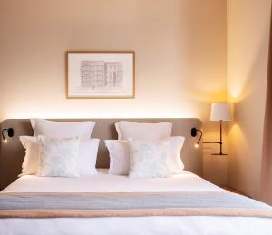 - une chambre avec un lit et des oreillers blancs dans l'établissement Residhome Paris Clamart, à Clamart