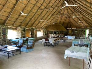 a large room with tables and chairs in a building at Bungalow 4 on this world renowned Eco site 40 minutes from Vic Falls Fully catered stay - 1988 in Victoria Falls