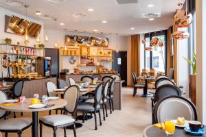 a restaurant with tables and chairs and a bar at Residhome Paris Clamart in Clamart
