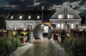 a white house with an archway in front of it at Hotel Bestseller in Kecskemét