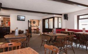 a restaurant with wooden tables and chairs in a room at Hotel Sport Cafe in Sauze dʼOulx