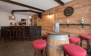 un bar con paredes de madera y taburetes rojos en un restaurante en Hotel Sport Cafe, en Sauze dʼOulx