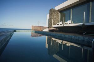 英雄港Casa das Cinco的一座游泳池,在建筑物的一侧有一艘船