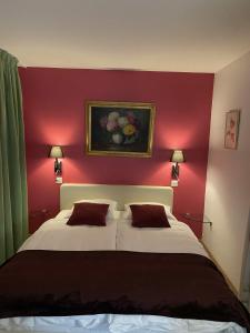 - une chambre avec un grand lit et un mur rouge dans l'établissement Auberge de Dully, à Dully