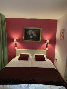 ein Schlafzimmer mit einem großen Bett mit einer roten Wand in der Unterkunft Auberge de Dully in Dully