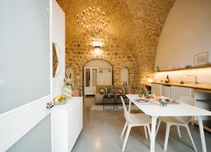 eine Küche und ein Wohnzimmer mit einem weißen Tisch und Stühlen in der Unterkunft Azamra Inn Tzfat in Safed
