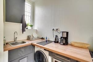 een keuken met een wastafel en een aanrecht bij Appartement charmant entièrement équipé in Ivry-sur-Seine