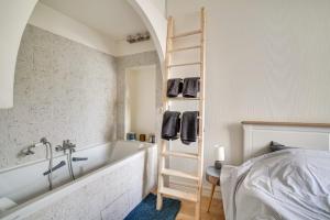 Appartement charmant entièrement équipé في إيفري سور سين: حمام مع حوض استحمام وسلم