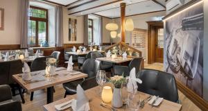 a restaurant with tables and chairs in a room at Pfalzhotel Asselheim in Asselheim