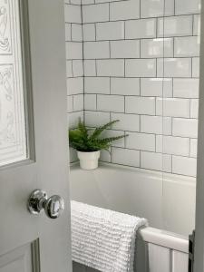 a bathroom with a tub and a potted plant at Old Pier Cottage Tarbert in Tarbert