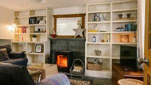 a living room with a fireplace and a tv at Old Pier Cottage Tarbert in Tarbert