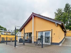 una piccola casa gialla con una recinzione nera di Haus Tierfreund a Hellenthal