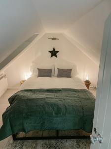 a bedroom with a large bed with a green blanket at Old Pier Cottage Tarbert in Tarbert