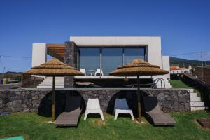 twee stoelen en twee paraplu's in een tuin bij Casa das Cinco in Angra do Heroísmo