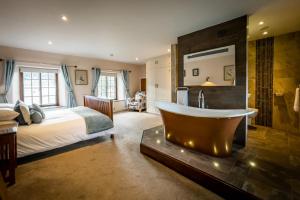 a bedroom with a bed and a tub in a room at Beautiful Grade 2 listed building - West Wing in Bowness-on-Windermere