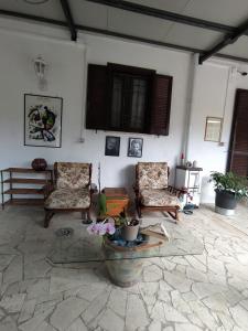 sala de estar con 2 sillas y mesa en Casa Privata Villa Roberta, en Fontechiari