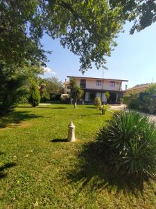 a fire hydrant in the grass in front of a building at Casa Privata Villa Roberta in Fontechiari