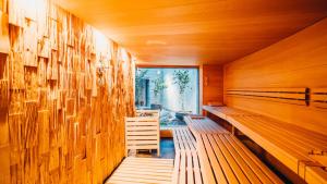 una sauna con bancos de madera y una ventana en Peaks Place Apartments & SPA, en Laax